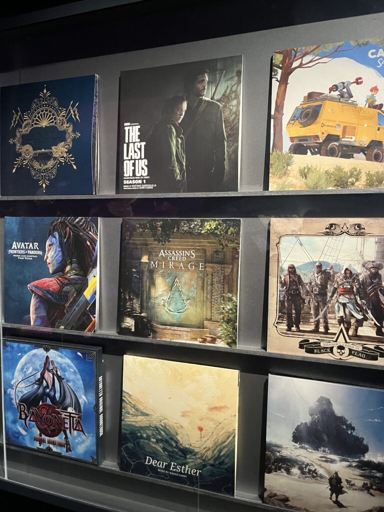 Video game soundtrack vinyl display at the Philharmonie 'Music and Video Games' exhibition, featuring The Last of Us and Assassin's Creed.